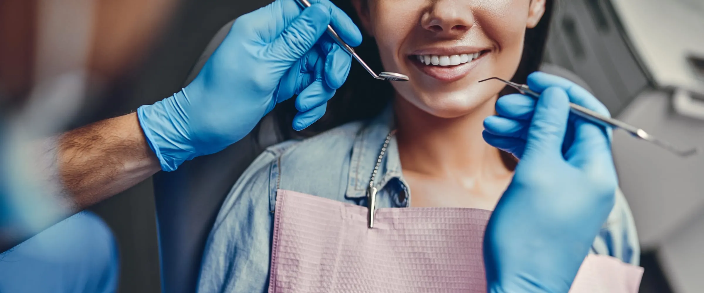 A dentist examining a patient's smile with a mirror and probe